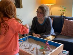 Lorraine using sand tray therapy with a child